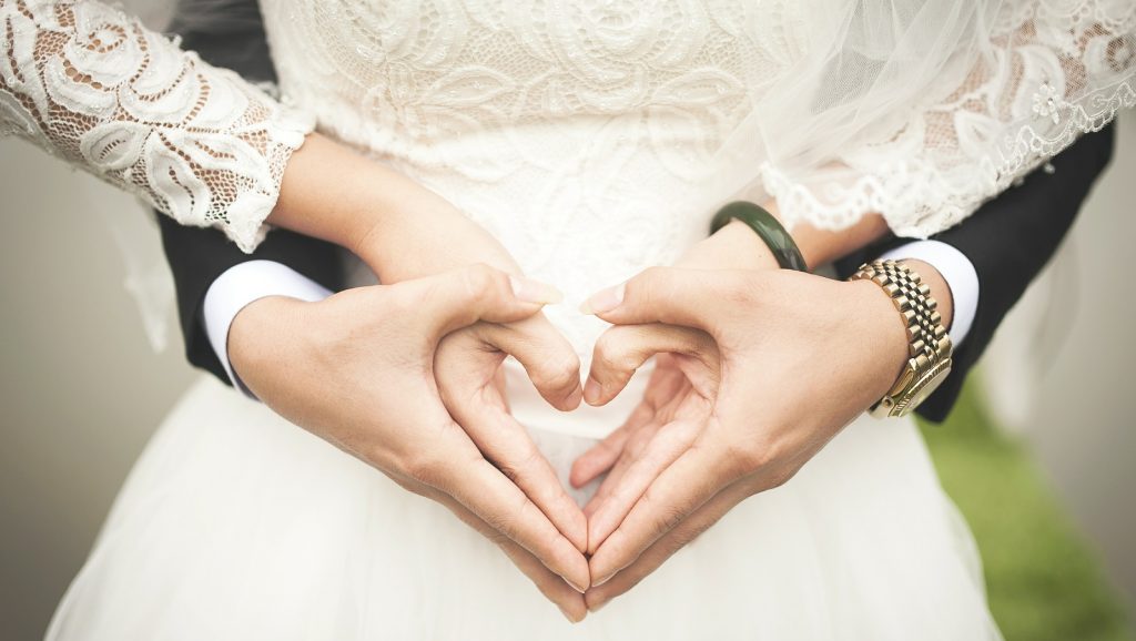 wedding couple forming heart with hands
